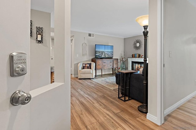 hallway featuring hardwood / wood-style floors and ornamental molding