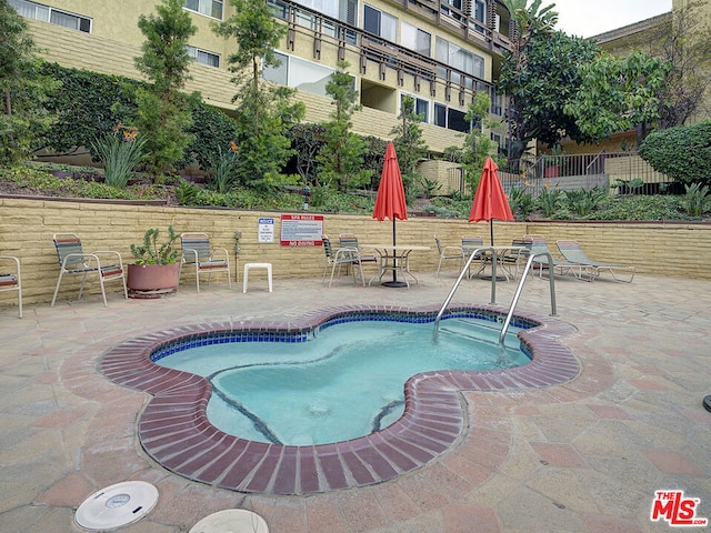 view of pool featuring a hot tub and a patio area