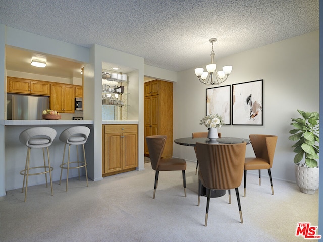 dining area with light colored carpet, a textured ceiling, and a chandelier