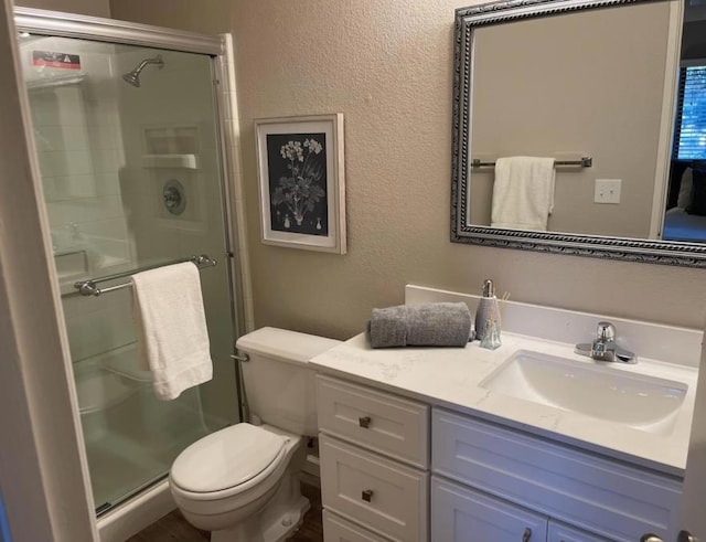 bathroom featuring vanity, toilet, and a shower with shower door