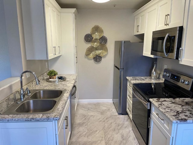 kitchen with white cabinetry, sink, stainless steel appliances, and light stone countertops