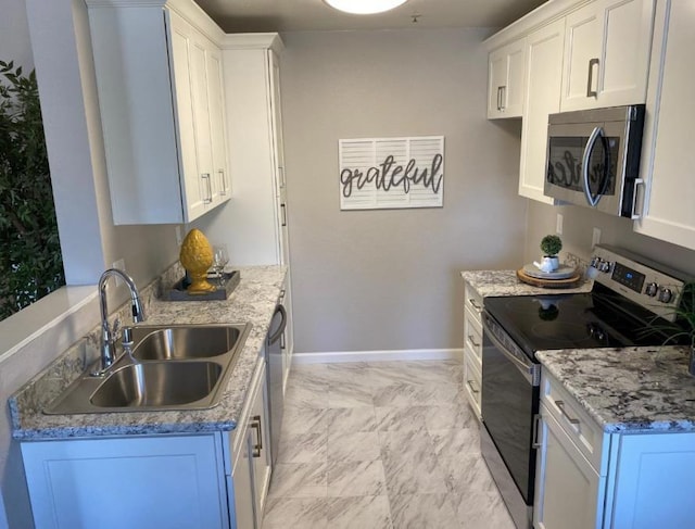 kitchen with white cabinetry, sink, stainless steel appliances, and light stone countertops