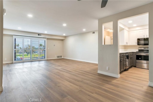 unfurnished living room featuring ceiling fan and light wood-type flooring