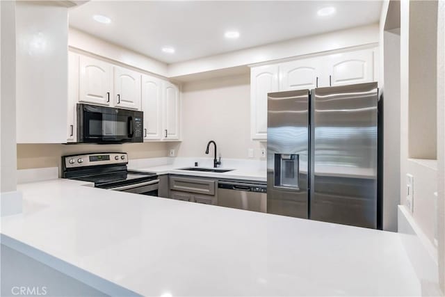 kitchen with kitchen peninsula, sink, white cabinetry, and stainless steel appliances