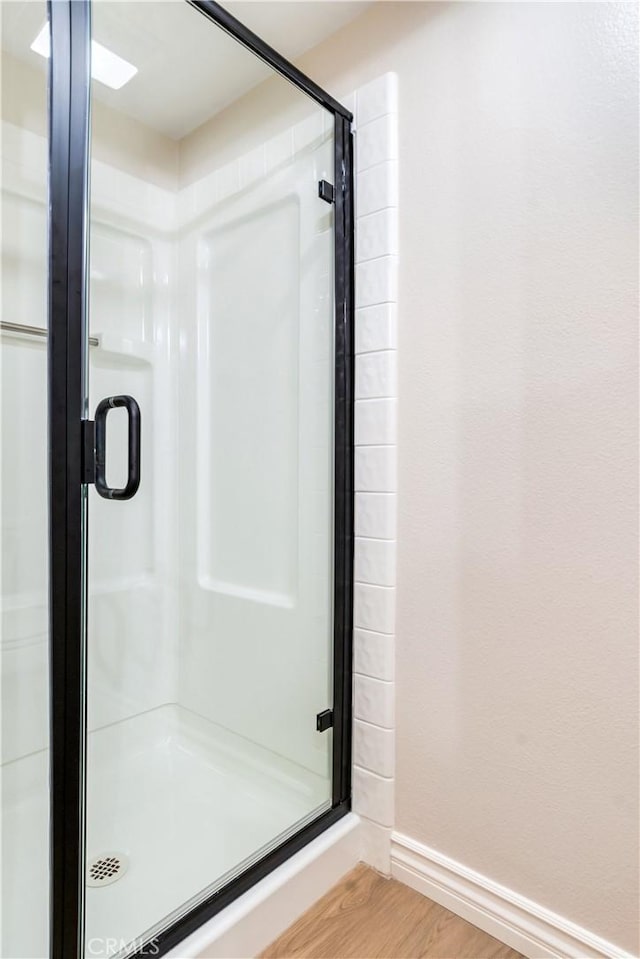 bathroom with hardwood / wood-style flooring and walk in shower