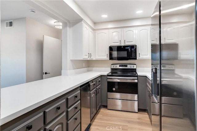 kitchen with kitchen peninsula, appliances with stainless steel finishes, light hardwood / wood-style flooring, and white cabinetry