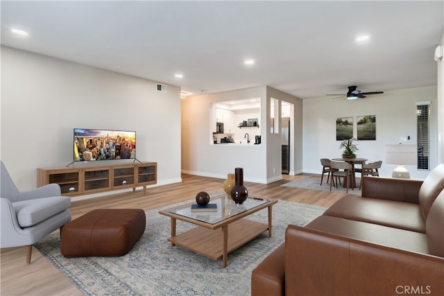 living room featuring hardwood / wood-style floors and ceiling fan