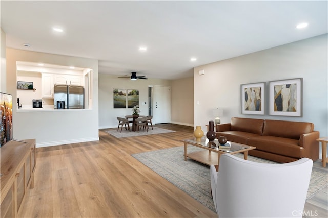 living room with ceiling fan and light wood-type flooring