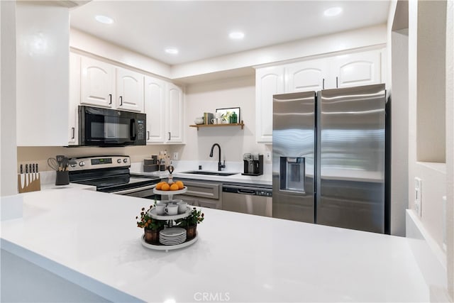 kitchen with kitchen peninsula, sink, white cabinets, and stainless steel appliances