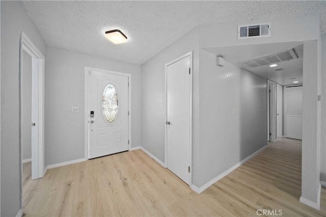 entrance foyer featuring light hardwood / wood-style floors and a textured ceiling