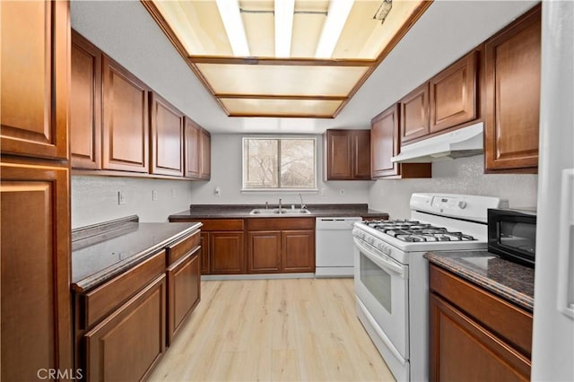 kitchen with white appliances, light hardwood / wood-style flooring, and sink