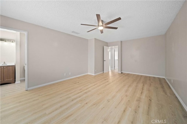 unfurnished bedroom with ensuite bath, ceiling fan, sink, light hardwood / wood-style flooring, and a textured ceiling