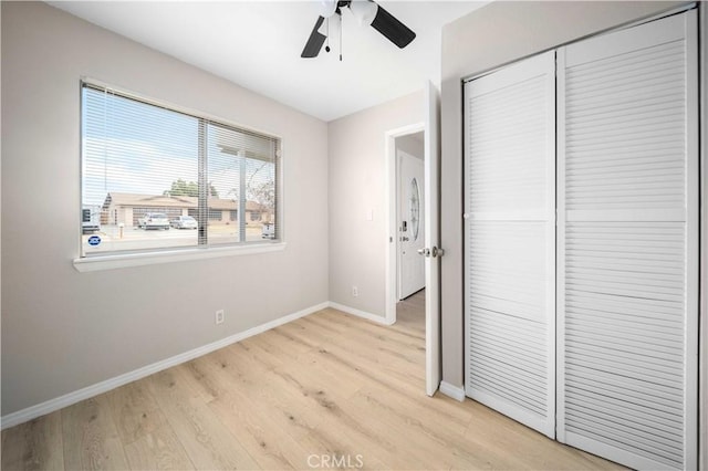 unfurnished bedroom with ceiling fan, a closet, and light hardwood / wood-style floors