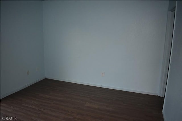 unfurnished room with dark wood-type flooring