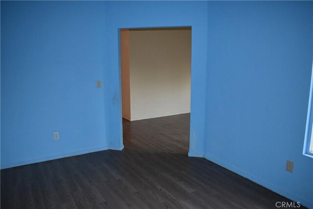 empty room with dark hardwood / wood-style flooring