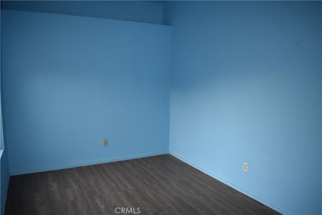 empty room with dark hardwood / wood-style flooring