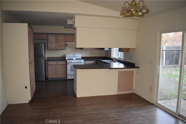 kitchen featuring dark hardwood / wood-style flooring, white gas range, sink, and stainless steel refrigerator