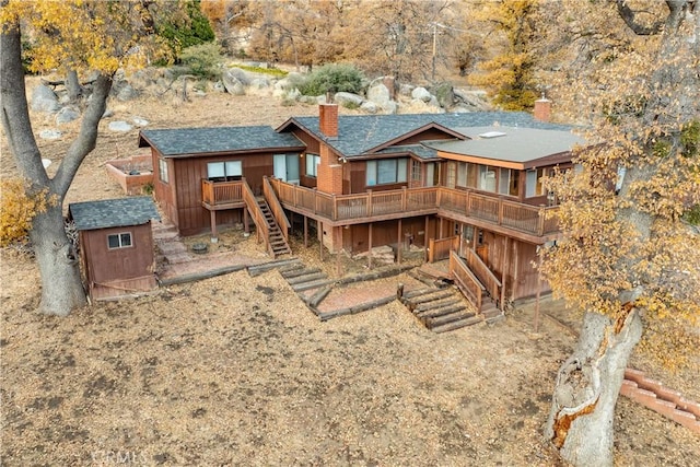 rear view of house featuring a deck and a storage unit