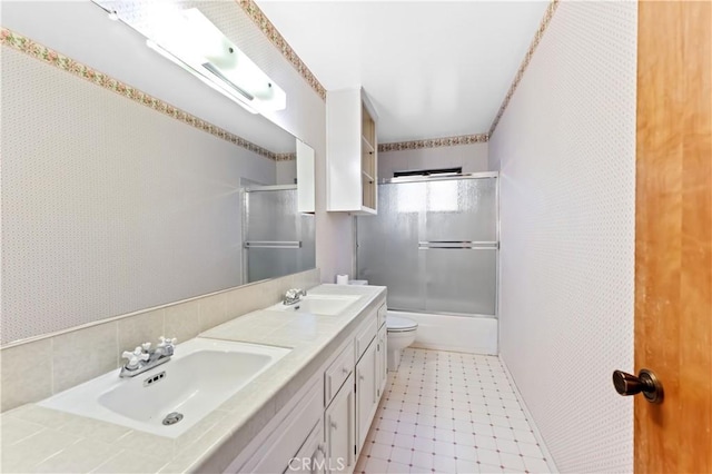 full bathroom featuring shower / bath combination with glass door, vanity, and toilet