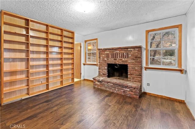 unfurnished living room with dark hardwood / wood-style floors, a fireplace, and a textured ceiling