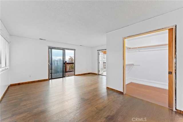 unfurnished bedroom with a closet, a textured ceiling, and hardwood / wood-style flooring