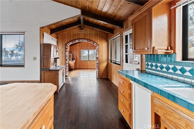 kitchen featuring wooden ceiling, wooden walls, vaulted ceiling with beams, dark hardwood / wood-style floors, and tile counters