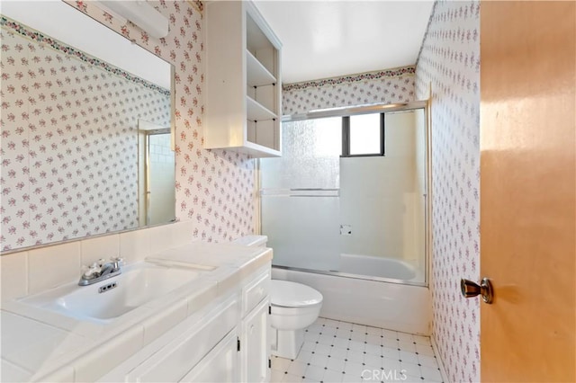 full bathroom featuring vanity, enclosed tub / shower combo, and toilet