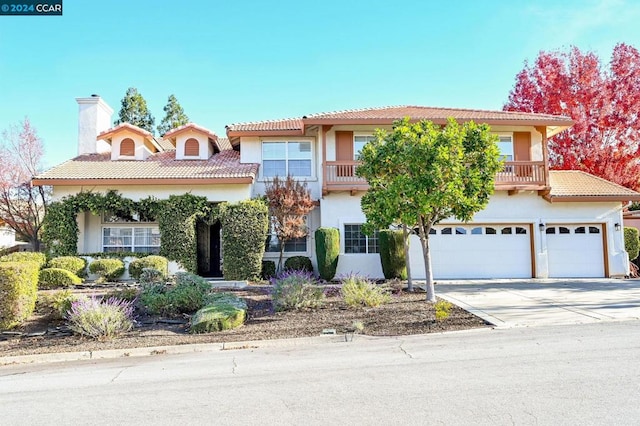 mediterranean / spanish house featuring a garage and a balcony