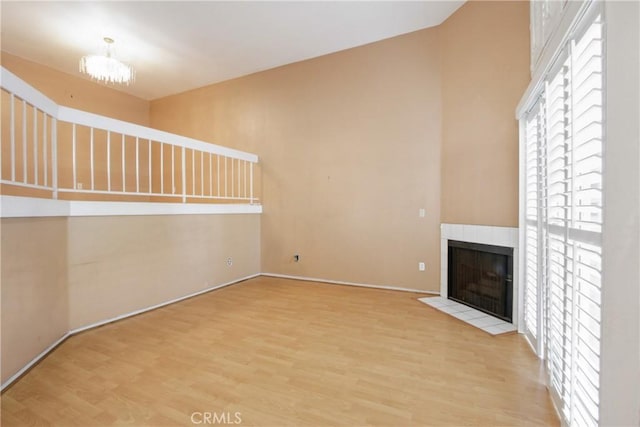 unfurnished living room featuring hardwood / wood-style flooring and a tile fireplace