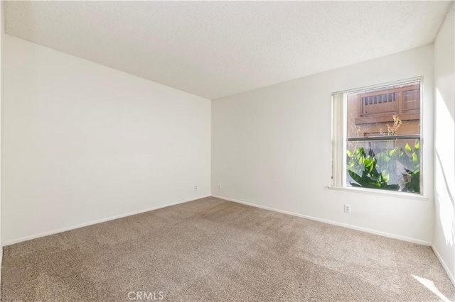 carpeted empty room featuring a textured ceiling