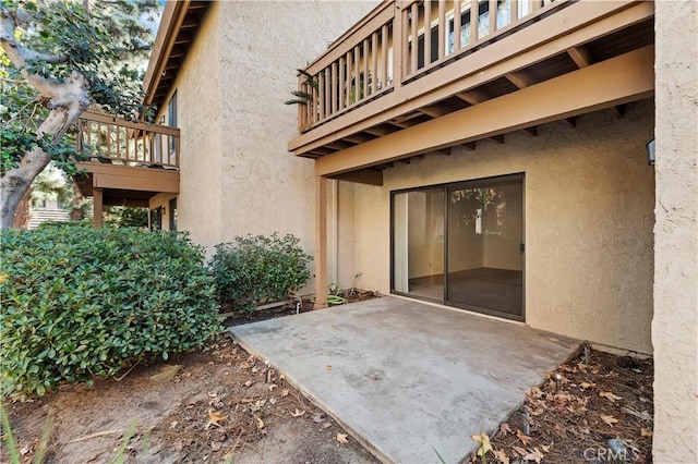 entrance to property featuring a patio and a balcony