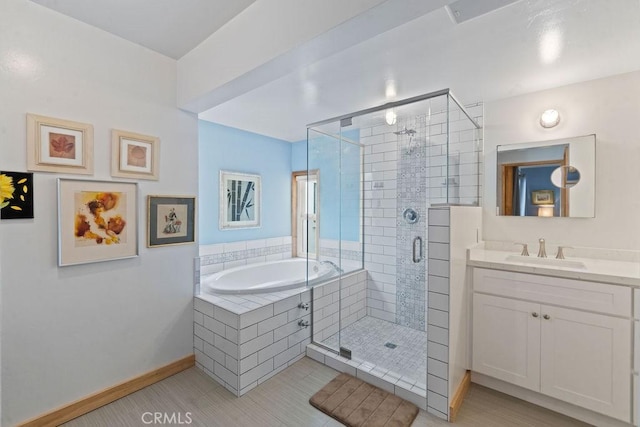 bathroom featuring plus walk in shower, vanity, and tile patterned flooring