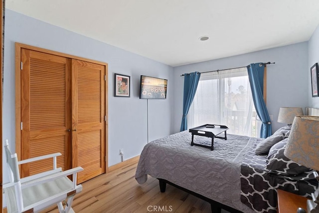 bedroom with light wood-type flooring and a closet