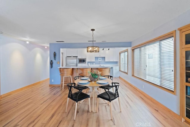 dining space featuring sink and light hardwood / wood-style flooring