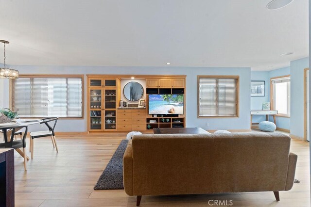 living room featuring light wood-type flooring and a chandelier