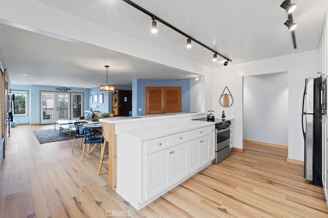 kitchen with pendant lighting, kitchen peninsula, white cabinetry, stainless steel electric stove, and french doors