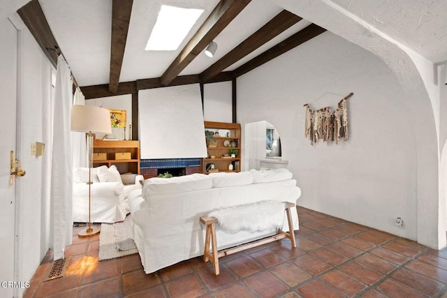 tiled living room with vaulted ceiling with beams