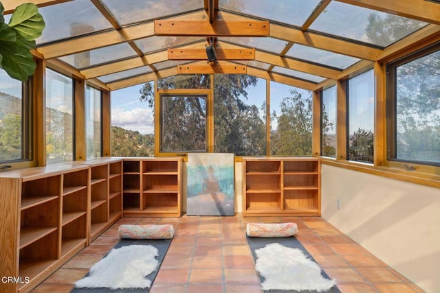 unfurnished sunroom featuring vaulted ceiling