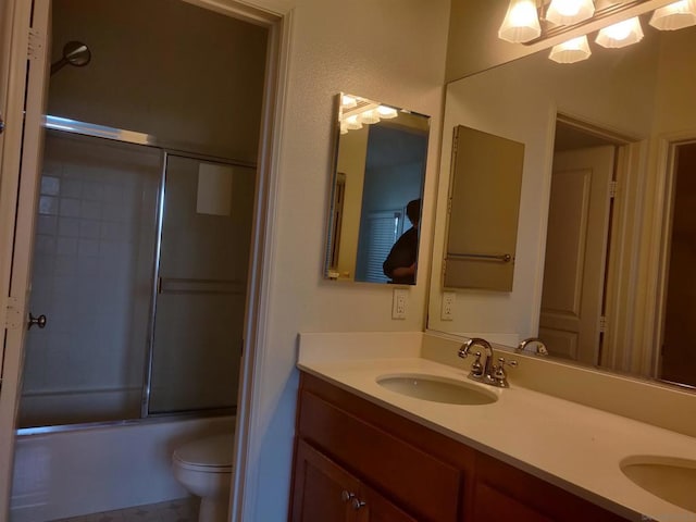 full bathroom featuring toilet, vanity, and combined bath / shower with glass door