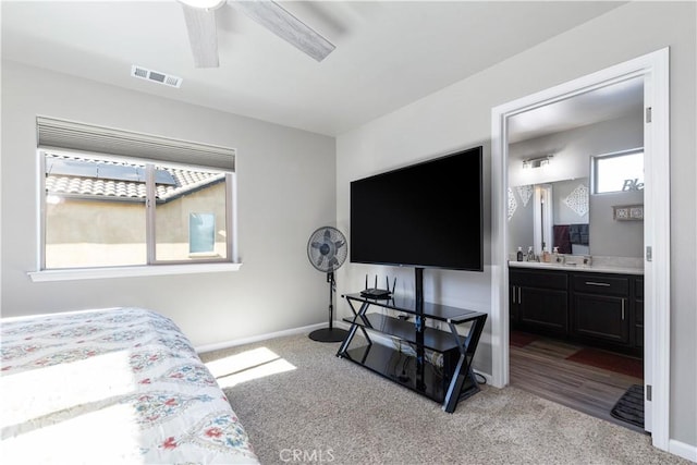 carpeted bedroom with ceiling fan and ensuite bathroom