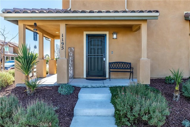 view of exterior entry featuring covered porch