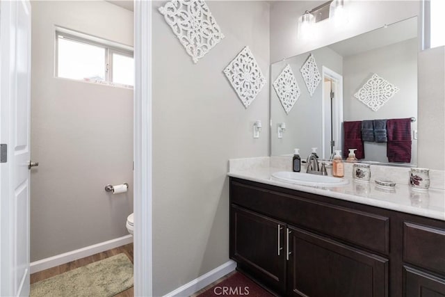 bathroom featuring hardwood / wood-style flooring, vanity, and toilet