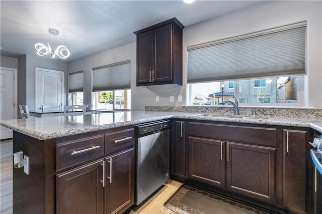 kitchen featuring kitchen peninsula, hanging light fixtures, light hardwood / wood-style floors, sink, and dishwasher