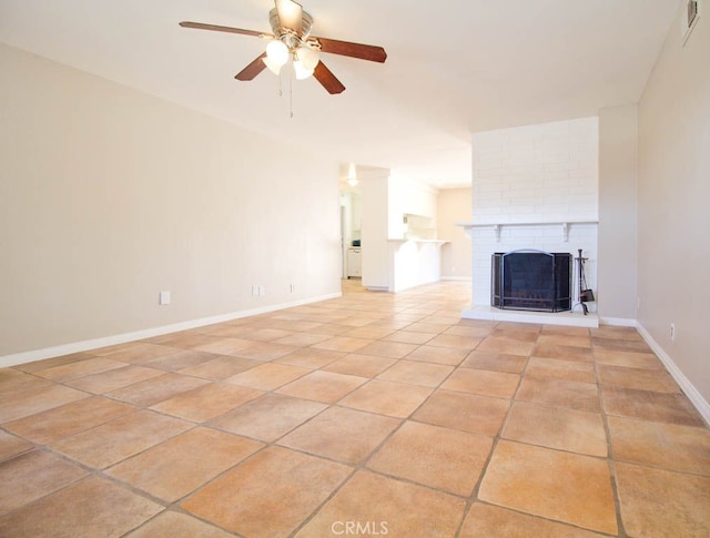 unfurnished living room featuring ceiling fan, light tile patterned flooring, and a brick fireplace