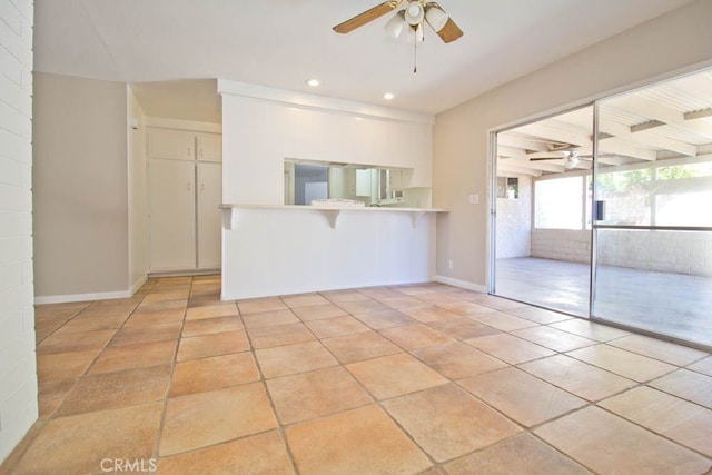 tiled spare room with ceiling fan