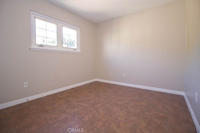 unfurnished room with dark tile patterned floors