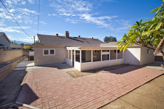 rear view of property featuring a patio area and a sunroom