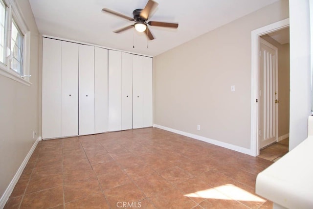 unfurnished bedroom featuring ceiling fan and multiple closets