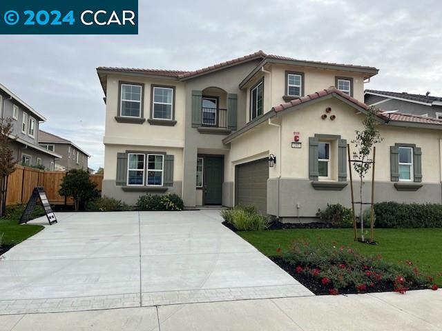 mediterranean / spanish-style home featuring a garage, a balcony, and a front lawn