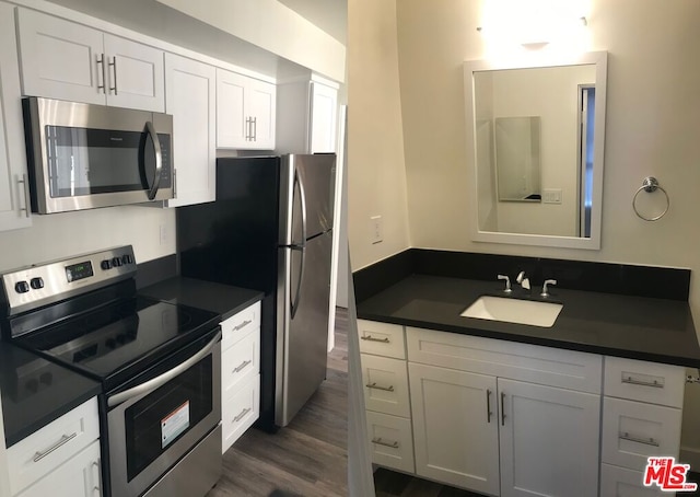 kitchen featuring white cabinetry, sink, dark wood-type flooring, and appliances with stainless steel finishes